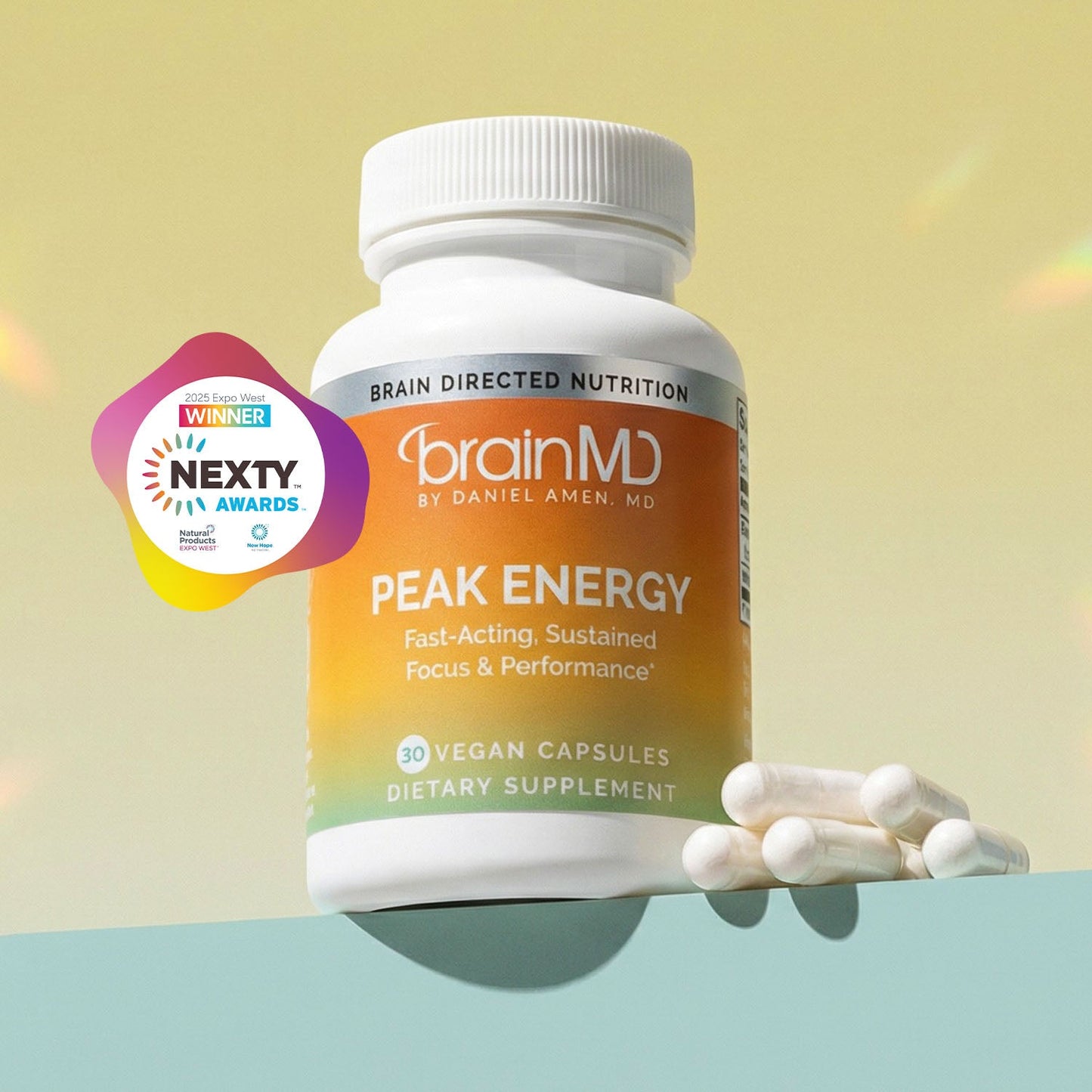 Orange supplement bottle with white capsules against a light yellow background