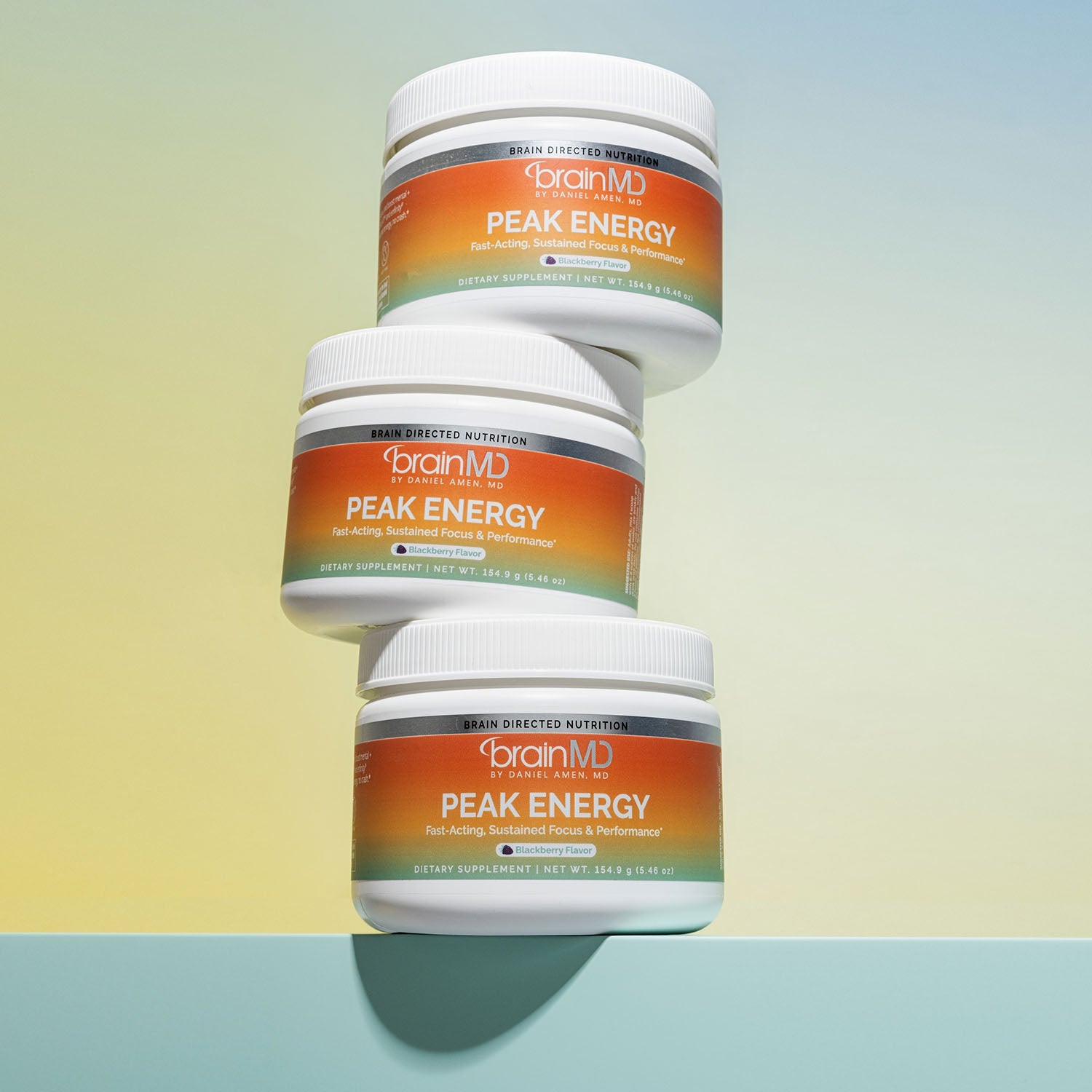 Three stacked supplement powder containers against a light yellow background